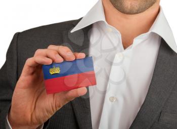 Businessman is holding a business card, flag of Liechtenstein