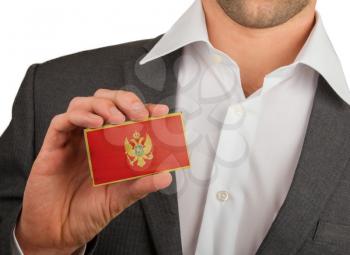 Businessman is holding a business card, flag of Montenegro