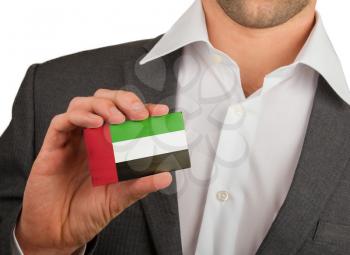 Businessman is holding a business card, flag of UAE
