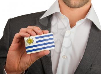 Businessman is holding a business card, flag of Uruguay