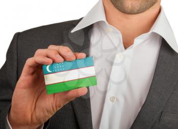 Businessman is holding a business card, flag of Uzbekistan