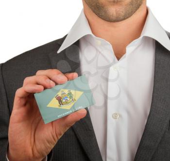 Businessman is holding a business card, flag of Delaware