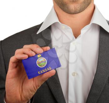 Businessman is holding a business card, flag of Kansas