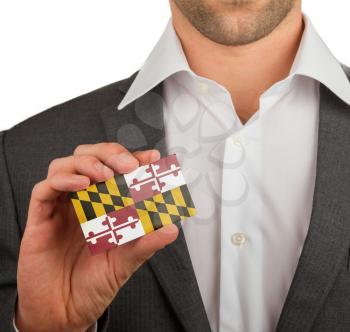 Businessman is holding a business card, flag of Maryland