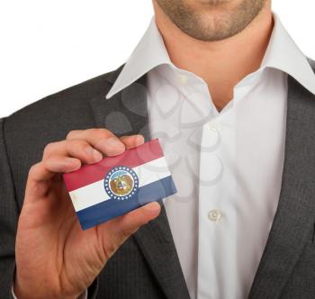 Businessman is holding a business card, flag of Missouri