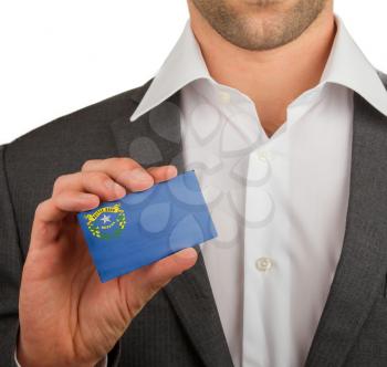 Businessman is holding a business card, flag of Nevada