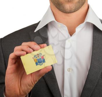Businessman is holding a business card, flag of New Jersey