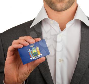 Businessman is holding a business card, flag of New York