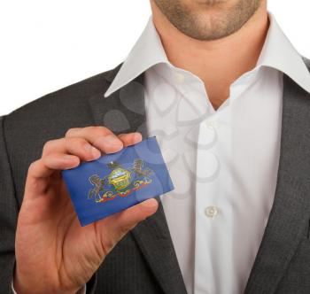 Businessman is holding a business card, flag of Pennsylvania
