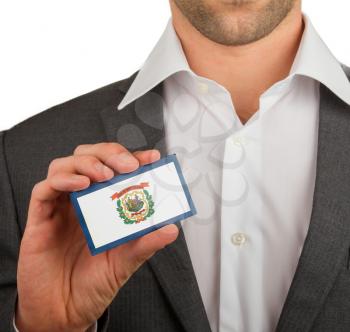 Businessman is holding a business card, flag of West Virginia