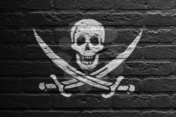 Brick wall with a painting of a flag isolated, Pirate