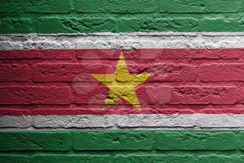 Brick wall with a painting of a flag isolated, Suriname