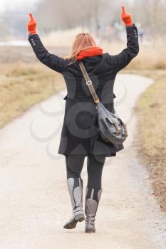 Woman dressed in warm clothing, making obscene gesture with fingers
