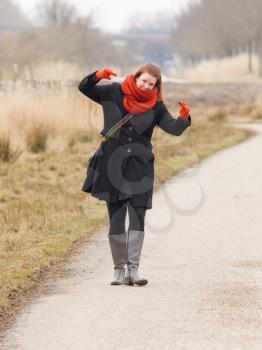 Woman dressed in warm clothing, making obscene gesture with fingers