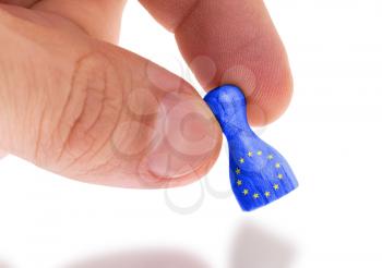 Hand holding wooden pawn with a flag painting, selective focus, European Union