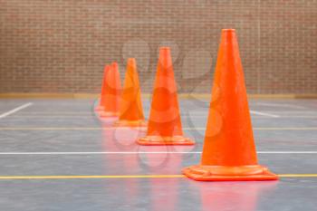 Interior of a gym at school, red cones on a row
