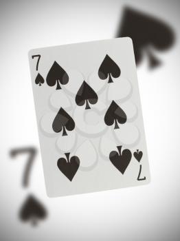 Playing card with a blurry background, seven of spades