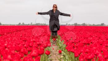 Woman standing in a field of tulips, selective focus