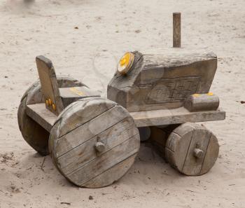 Wooden toy tractor with trailer in the sand