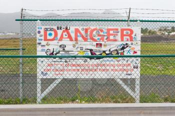 PRINCESS JULIANA AIRPORT, ST MARTIN - JULY 19, 2013: Warning sign by Maho beach about low planes on July 19, 2013. The 2300m runway is approached over the sea.