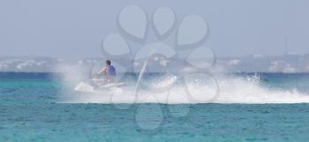 Young guy cruising on the Caribbean Sea on a jet ski