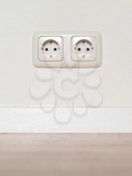 Electrical jack white plastic socket on a white wall