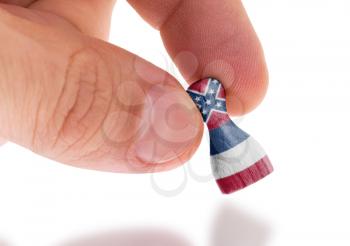 Hand holding wooden pawn with a flag painting, selective focus, Mississippi