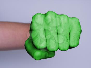Very hairy knuckles from the fist of a man punching, green skin