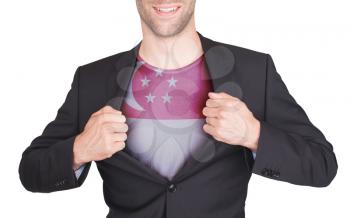 Businessman opening suit to reveal shirt with flag, Singapore