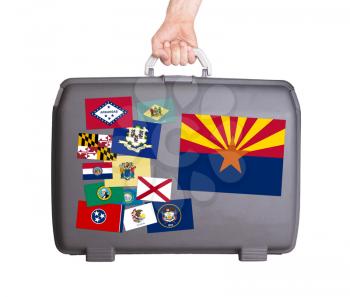 Used plastic suitcase with stains and scratches, stickers of US States, Arizona