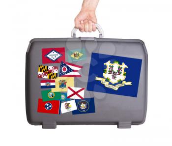 Used plastic suitcase with stains and scratches, stickers of US States, Connecticut