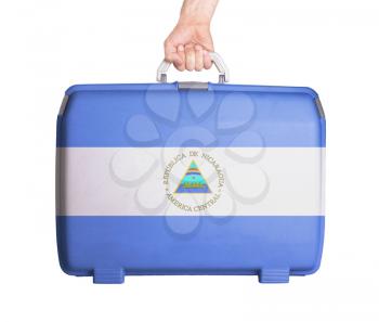 Used plastic suitcase with stains and scratches, printed with flag, Nicaragua