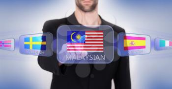 Hand pushing on a touch screen interface, choosing language or country, Malaysia