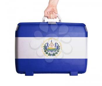 Used plastic suitcase with stains and scratches, printed with flag, El Salvador