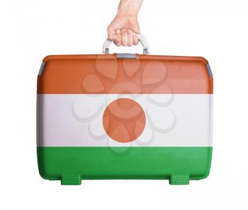 Used plastic suitcase with stains and scratches, printed with flag, Niger