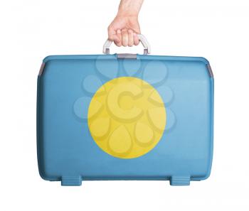 Used plastic suitcase with stains and scratches, printed with flag, Palau