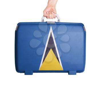 Used plastic suitcase with stains and scratches, printed with flag, Saint Lucia