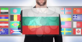 Hand pushing on a touch screen interface, choosing language or country, Bulgaria