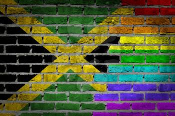 Dark brick wall texture - coutry flag and rainbow flag painted on wall - Jamaica