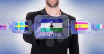 Hand pushing on a touch screen interface, choosing language or country, Lesotho