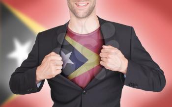 Businessman opening suit to reveal shirt with flag, East Timor