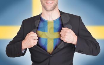 Businessman opening suit to reveal shirt with flag, Sweden