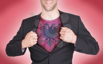 Businessman opening suit to reveal shirt with flag, Albania