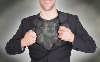 Businessman opening suit to reveal shirt, army camouflage