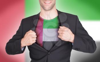 Businessman opening suit to reveal shirt with flag, United Arab Emirates