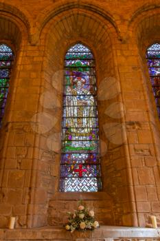 Big window in a small Scottish cathedral, yellow lights