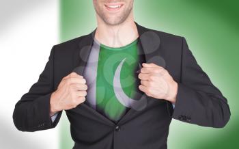 Businessman opening suit to reveal shirt with flag, Pakistan