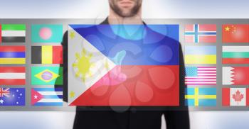 Hand pushing on a touch screen interface, choosing language or country, the Philippines