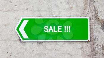 Green sign on a concrete wall - Sale