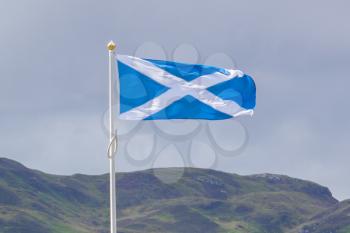 Scotland flag waving in the wind, cloudy sky